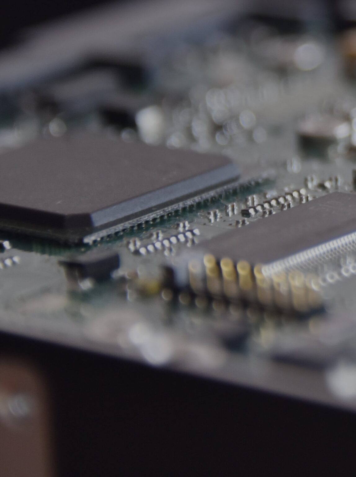 A close-up photograph of an electronic circuit board, reminiscent of the precision in confidential waste disposal. The image highlights intricate components like a central chip and metallic connectors against a blurred background, emphasizing the detailed circuitry.